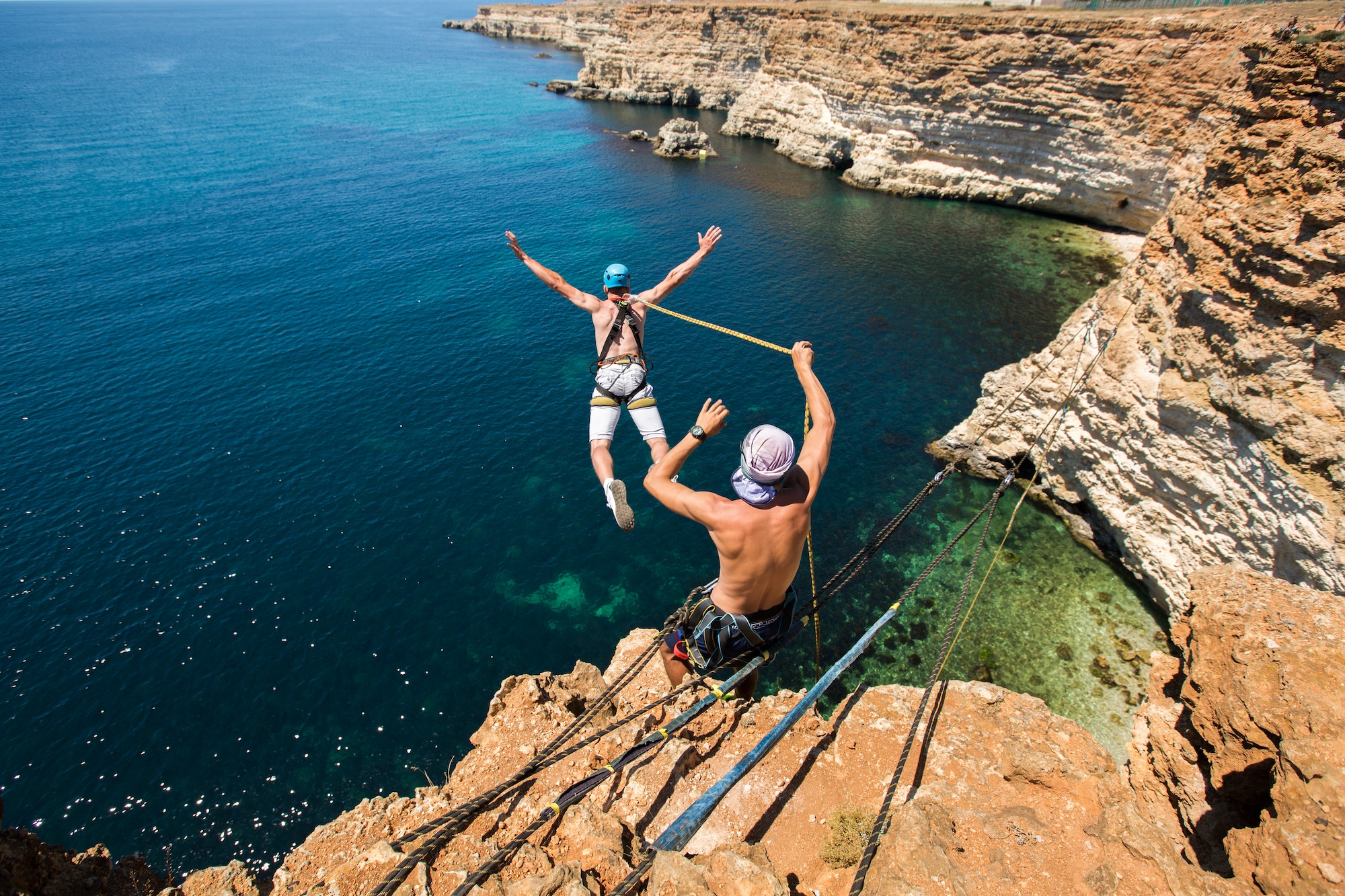 melhores seguros de viagem, Rope jumping off a cliff with a rope in the water. The ocean. Sea. Mountain