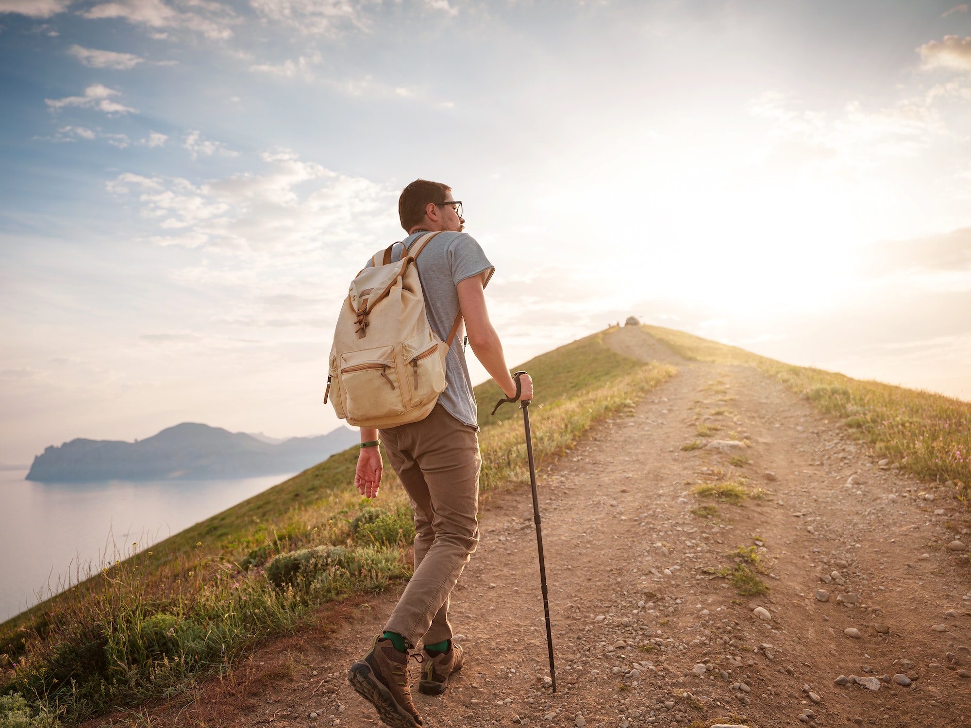 Young man travels alone on the backdrop of the mountains